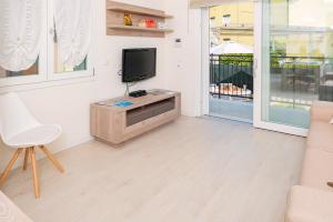 een woonkamer met een tv en een witte stoel bij Family house Bivio in Peschiera del Garda