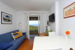 a living room with a blue couch and a bed at Lemechi Casa Belfior Apartments in Rabac