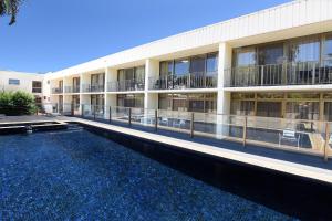 un bâtiment avec une piscine en face d'un bâtiment dans l'établissement Comfort Inn Grammar View, à Toowoomba