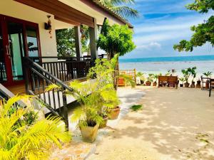 een huis met planten op het strand bij Ibiza Bungalows in Haad Yao