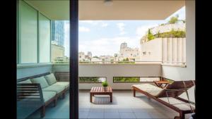 salon z kanapą i krzesłami na balkonie w obiekcie Sunny Luxury Apartments w Tel Awiwie