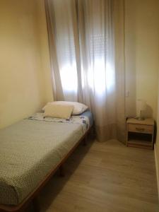 a small bedroom with a bed and a window at Cozy Flat in Alicante