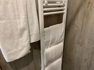 einen Handtuchhalter mit weißen Handtüchern im Bad in der Unterkunft TWT Motel in Triptis