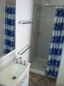 a bathroom with a sink and a shower with a shower curtain at Mataranka Roadhouse in Mataranka