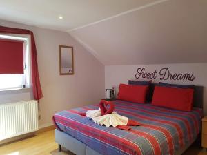 a bedroom with a bed with a red and blue blanket at B&B Woodside in Torhout +48 photos