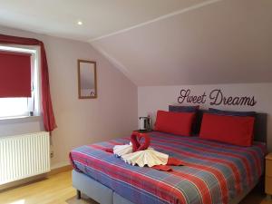 a bedroom with a bed with a red and blue blanket at B&B Woodside in Torhout