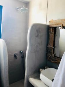 uma casa de banho com um chuveiro, um WC e um lavatório. em Sarakiniko View Studios em Mandrakia mais 19 fotografias