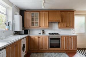 uma cozinha com armários de madeira e um lavatório em Henley self catering House em Henley on Thames