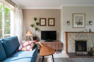 a living room with a blue couch and a fireplace at Henley self catering House in Henley on Thames