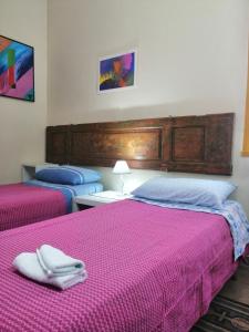 two beds in a room with pink and blue sheets at La casa del corso in Aragona