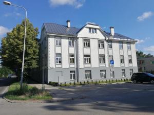 a large white building with a car parked in front of it at S7 Apartment in Rīga