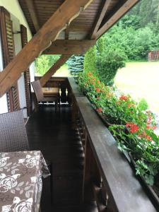 a porch with flowers and a table and chairs at Ferienwohnungen Schleich in Nassereith