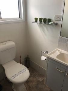a bathroom with a white toilet and a sink at Mataranka Roadhouse in Mataranka