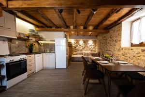 a kitchen with white appliances and a wooden ceiling at Matafia's House in Kalamitsi