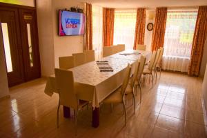 a dining room with a long table and chairs at Pensiunea La Cernat in Şugag