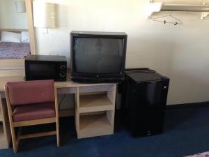 a television sitting on a desk in a hotel room at Relax Inn Forth Worth in Fort Worth