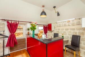 a kitchen with red cabinets and a red island at Juliette's Palace Studios in Dubrovnik