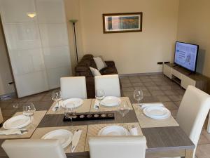 uma sala de jantar com uma mesa e cadeiras e um sofá em Holiday Dreams em Francavilla al Mare