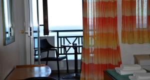 a room with a balcony with a table and a chair at Big Blue Studios in Kallithea Halkidikis
