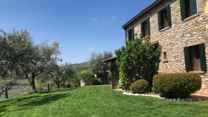 Holiday House Petrarca في أركوا بتراركا: منزل حجري مع حديقة خضراء بجوار مبنى