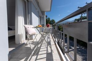 balkon z dwoma krzesłami i stołem na domu w obiekcie Avra Apartment w Kalamácie