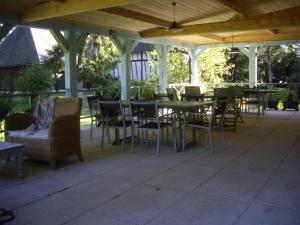 a patio with tables and chairs under a pavilion at La Grange des Marettes in Cléres