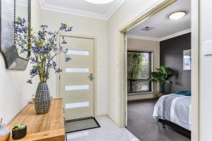 a bedroom with a bed and a vase with flowers on a table at Accommodation on Lansell 2 in Mount Gambier
