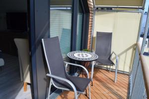 a balcony with two chairs and a table on a balcony at Beach House Seebude in Büsum