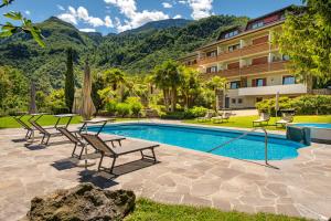 a swimming pool with chairs and a hotel at Hotel Wilma in Nalles