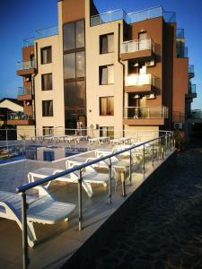 a building with a pool with tables and chairs in front of it at Aparthotel Afrodita 2 in Sinemorets