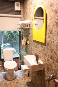 a bathroom with a toilet and a sink and a mirror at Carefree Park in Taichung