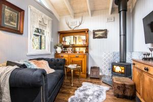 a living room with a couch and a wood stove at Juniper & Rye cottage for two in Ferny Creek