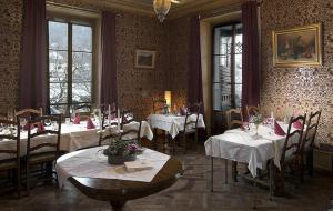 um restaurante com mesas e cadeiras com toalhas de mesa brancas em Au Vieux Manoir em Monthey