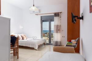 a bedroom with two beds and a view of the ocean at Coral Sea Studio in Kókkinos Pírgos