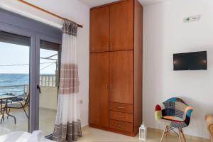a bedroom with a sliding glass door to the ocean at Coral Sea Studio in Kókkinos Pírgos