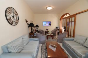 una sala de estar con sofás y un reloj en la pared en G. Kiapekou, en Loutra Edipsou