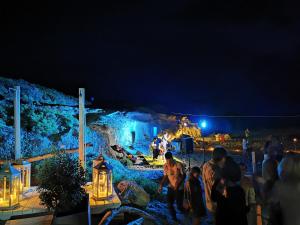 grupa ludzi stojących w nocy w parku rozrywki w obiekcie Hotel Hieracon w mieście Carloforte