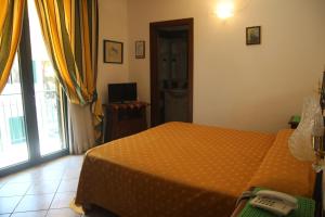 sypialnia z łóżkiem z telefonem w obiekcie Hotel La Barcarola w mieście Marina di Campo
