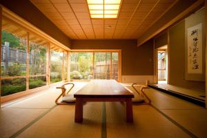 una camera con un tavolo di fronte ad una grande finestra di Yufuin Hoteiya a Yufu