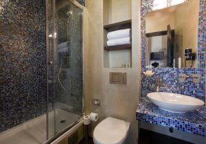 ein Bad mit einem WC, einem Waschbecken und einer Dusche in der Unterkunft Design Hotel Jewel Prague in Prag