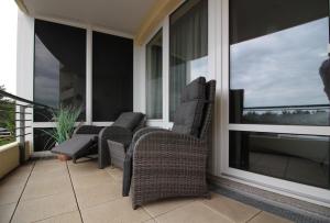 porche con 2 sillas y balcón con ventanas en Kurpark-Residenz W112, en Cuxhaven