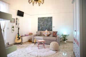 a living room with a couch and a guitar at Il Segnalibro B&B in Alberobello