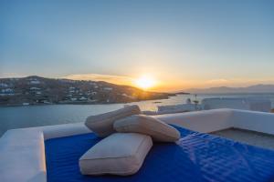 un grupo de almohadas en el borde de un barco con la puesta de sol en The Corfos Hills House, en Ornos