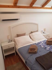 a bedroom with a bed with a blue and white blanket at Little Green House in Komiža