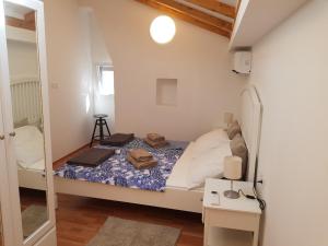 a small bedroom with a bed and a mirror at Little Green House in Komiža
