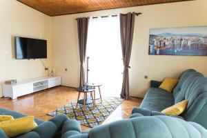 a living room with a blue couch and a tv at Villa Nava in Benkovac