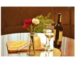 - une table avec une bouteille de vin et un vase avec des fleurs dans l'établissement Apartmani Baljak, à Livno