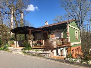 a green house with a balcony on the side of it at La Mermellina, 22 in Arriondas