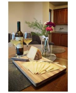 - une table avec une assiette de fromage et une bouteille de vin dans l'établissement Apartmani Baljak, à Livno
