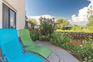a pair of green chairs sitting on a patio at Apartment Adrijana in Vrbnik